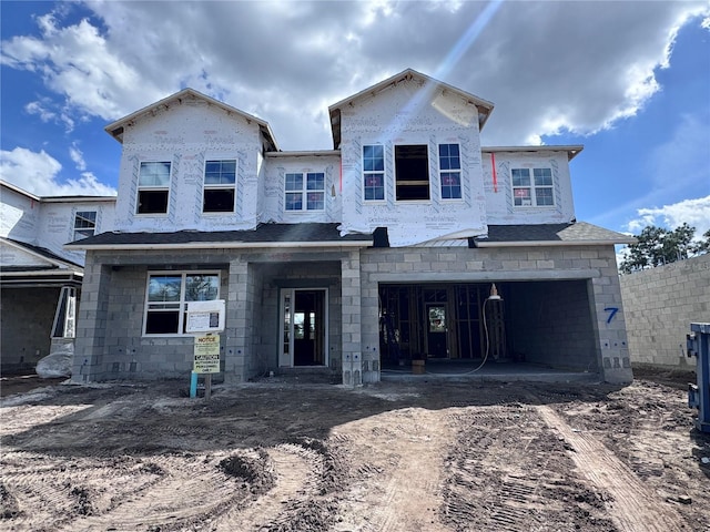 property under construction featuring a garage, roof with shingles, and driveway