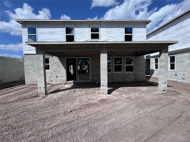 rear view of house with concrete block siding