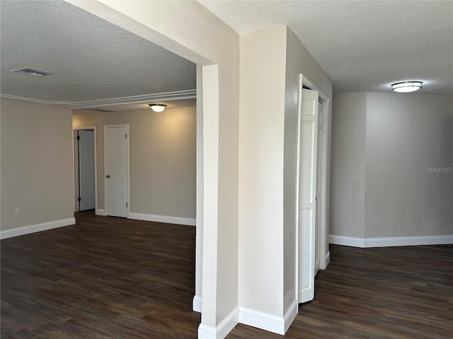 hallway with dark wood-type flooring and a textured ceiling