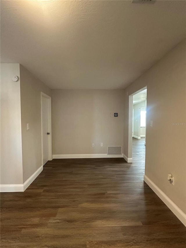 unfurnished room with dark hardwood / wood-style flooring