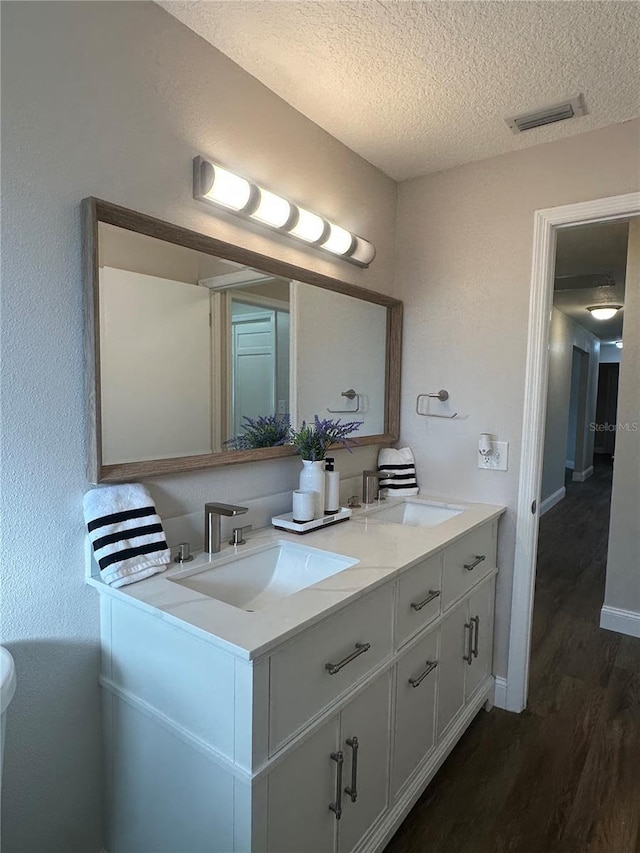 bathroom with vanity, hardwood / wood-style floors, and a textured ceiling