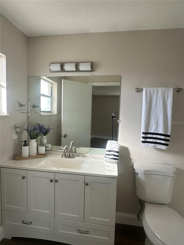 bathroom featuring vanity, toilet, and a textured ceiling