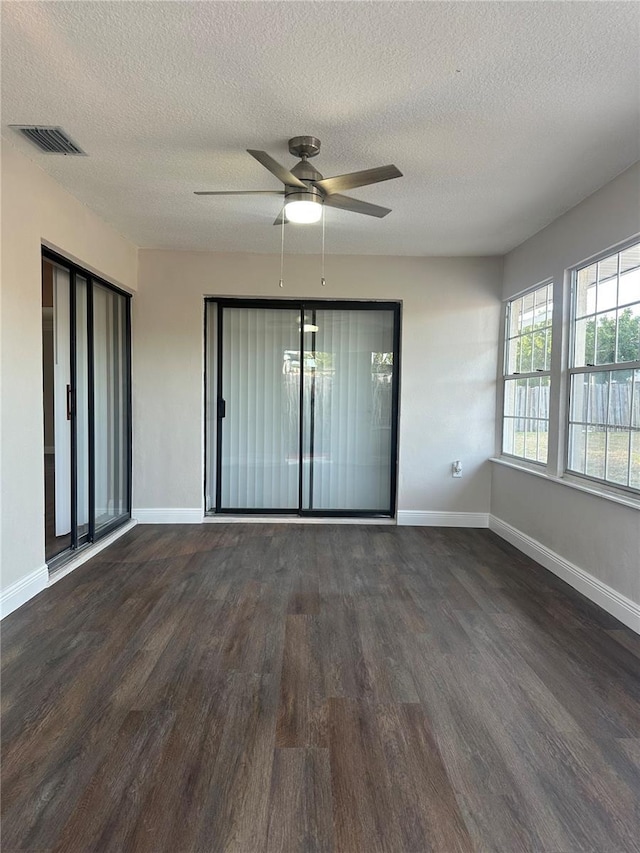 spare room featuring ceiling fan, dark wood-type flooring, and a textured ceiling