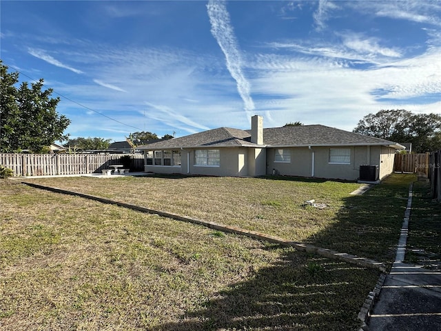 rear view of house with a yard and cooling unit