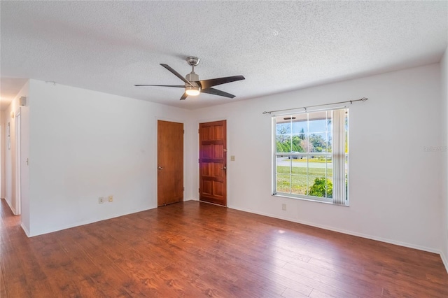 spare room with dark hardwood / wood-style flooring, ceiling fan, and a textured ceiling