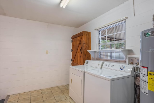 laundry room with electric water heater, light tile patterned floors, and independent washer and dryer