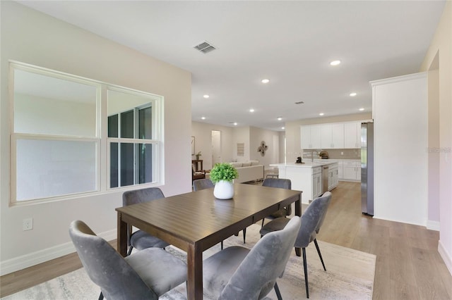 dining room featuring sink and light wood-type flooring