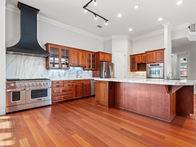 kitchen featuring stainless steel appliances, a kitchen bar, sink, and custom exhaust hood