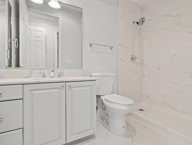 bathroom with vanity, a tile shower, and toilet