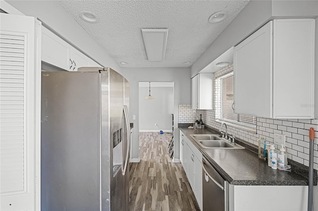 kitchen with white cabinetry, appliances with stainless steel finishes, sink, and decorative backsplash