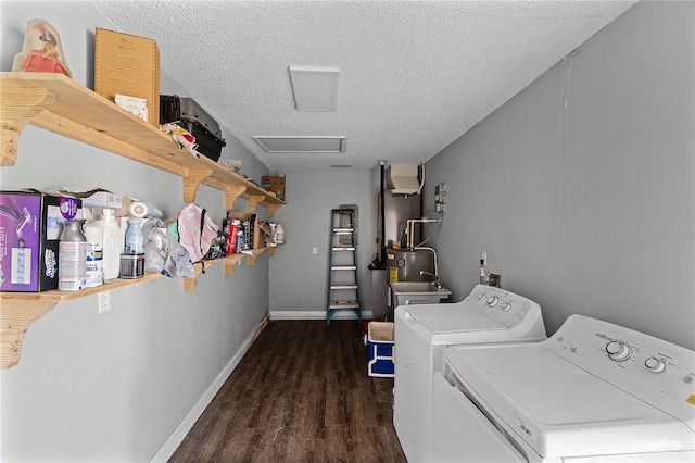 laundry room with dark hardwood / wood-style floors, washer and clothes dryer, and a textured ceiling