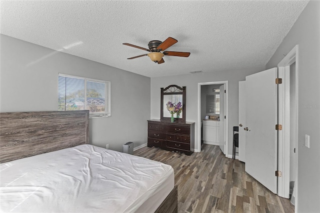 bedroom with ceiling fan, hardwood / wood-style flooring, and a textured ceiling