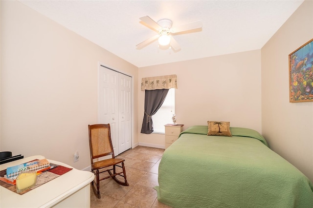 tiled bedroom with ceiling fan and a closet