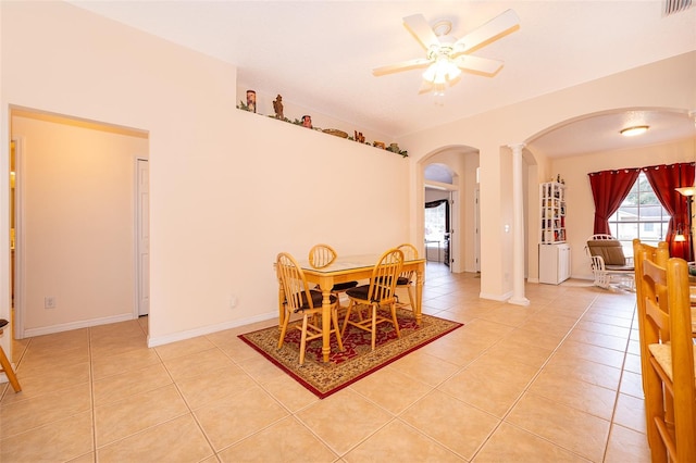 dining space with decorative columns, light tile patterned floors, arched walkways, visible vents, and a ceiling fan