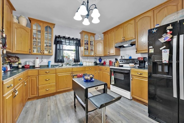 kitchen with electric range oven, black fridge with ice dispenser, decorative light fixtures, and light hardwood / wood-style floors