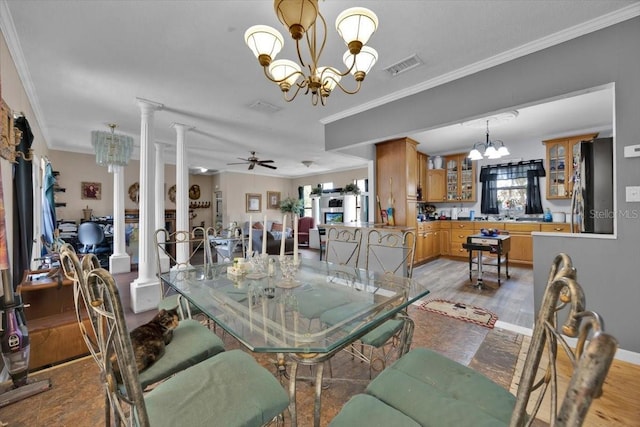 dining room featuring ceiling fan with notable chandelier, a wealth of natural light, ornamental molding, and ornate columns