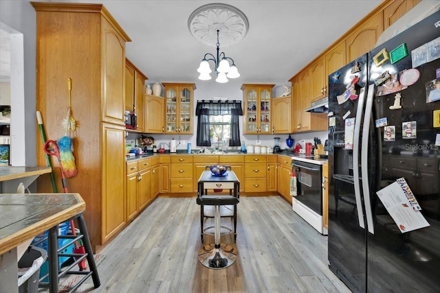 kitchen featuring white electric range, light hardwood / wood-style flooring, an inviting chandelier, hanging light fixtures, and black fridge