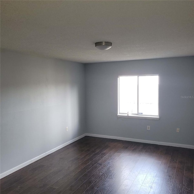 spare room with dark wood-type flooring