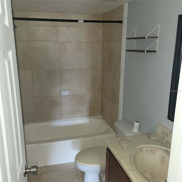 full bathroom with tile patterned flooring, vanity, tiled shower / bath combo, and toilet