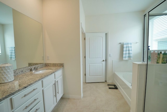 bathroom featuring vanity, a washtub, and tile patterned floors