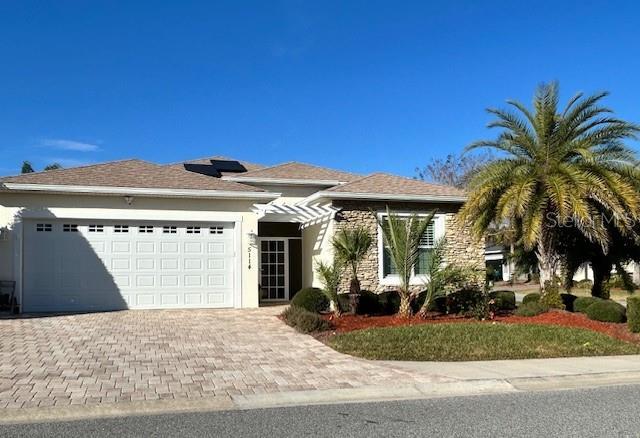 view of front of property featuring a garage and solar panels