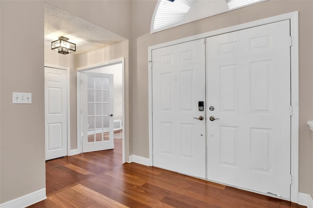 foyer with wood-type flooring and a textured ceiling