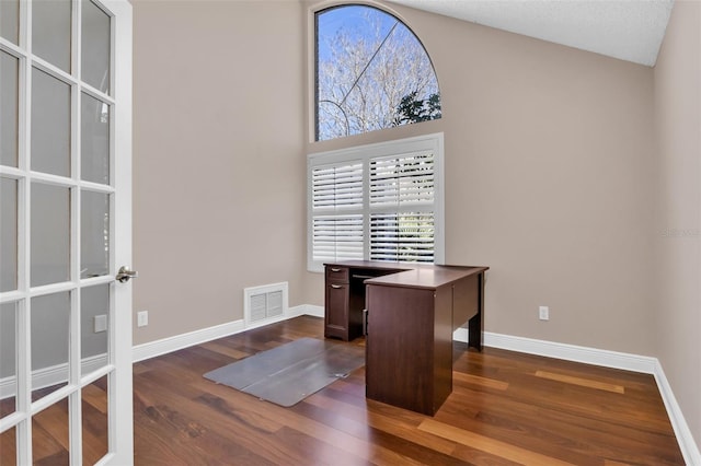 office space with vaulted ceiling and dark hardwood / wood-style flooring