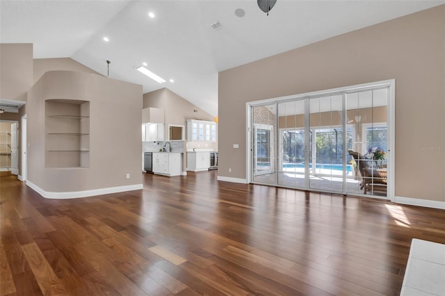 unfurnished living room featuring lofted ceiling, dark hardwood / wood-style flooring, and sink