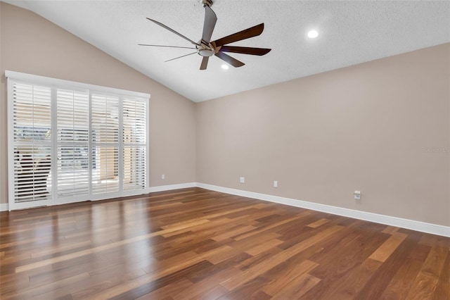 empty room featuring ceiling fan, dark hardwood / wood-style flooring, vaulted ceiling, and a textured ceiling