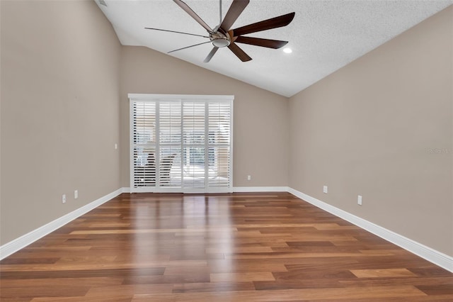 empty room featuring hardwood / wood-style flooring, vaulted ceiling, a textured ceiling, and ceiling fan