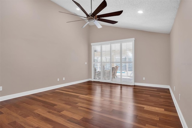 spare room with vaulted ceiling, dark hardwood / wood-style floors, and a textured ceiling