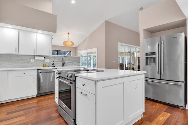 kitchen with decorative light fixtures, tasteful backsplash, white cabinets, dark hardwood / wood-style flooring, and stainless steel appliances