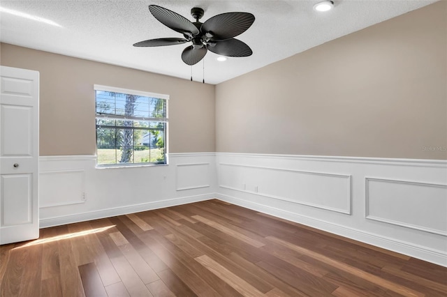 unfurnished room with ceiling fan, wood-type flooring, and a textured ceiling