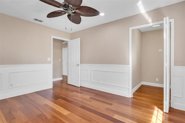 empty room with ceiling fan and hardwood / wood-style floors