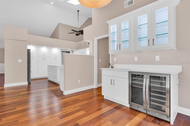 kitchen with wine cooler, white cabinetry, high vaulted ceiling, dark hardwood / wood-style flooring, and ceiling fan