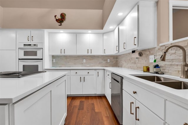 kitchen with sink, white cabinetry, dishwasher, double oven, and black electric stovetop