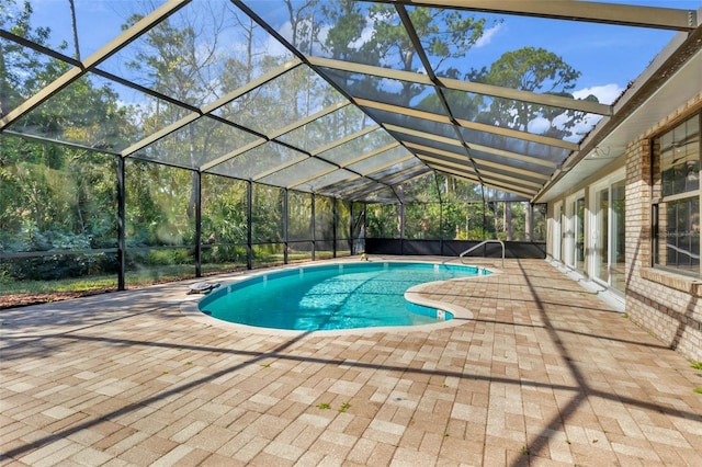 view of swimming pool featuring a patio and glass enclosure