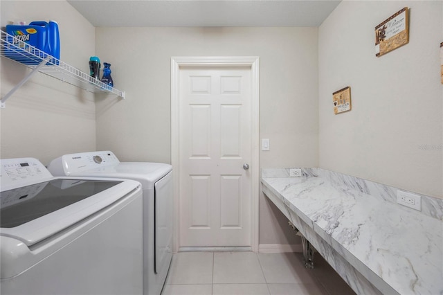 clothes washing area with light tile patterned flooring and independent washer and dryer