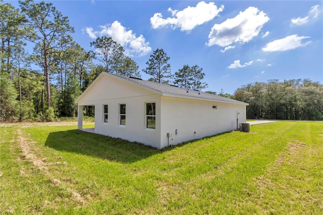 9095 SW 125th Ter, Dunnellon, FL 34432 - view of home's exterior with a lawn, stucco siding, and central AC