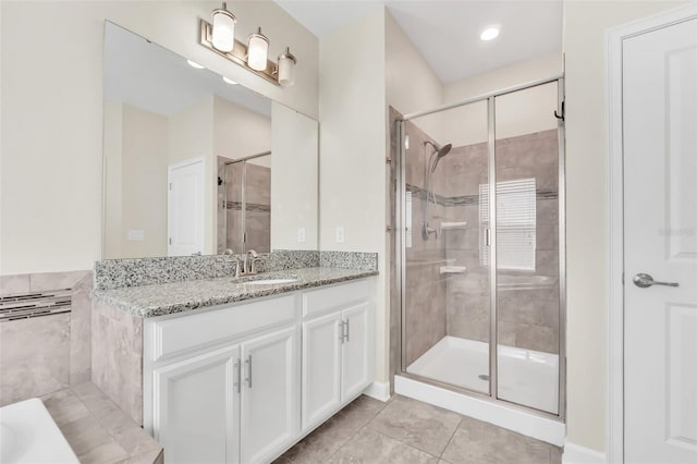 bathroom featuring vanity, a shower with shower door, and tile patterned floors