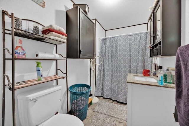 bathroom with walk in shower, vanity, and toilet