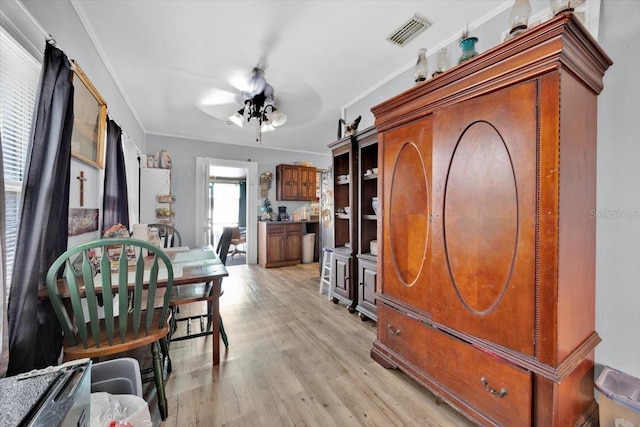 interior space with light hardwood / wood-style flooring, ornamental molding, and ceiling fan