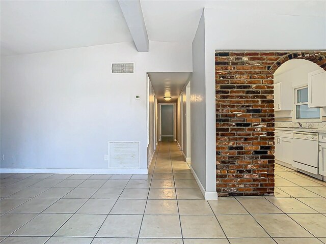 corridor with vaulted ceiling with beams and light tile patterned floors