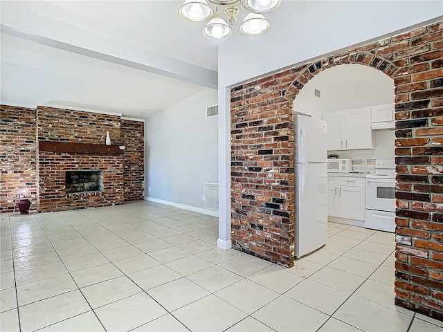 unfurnished living room with vaulted ceiling with beams, a fireplace, brick wall, and light tile patterned flooring