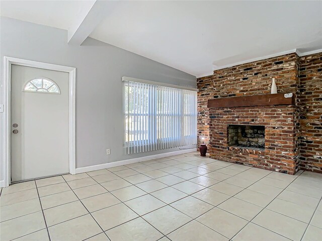 unfurnished living room featuring lofted ceiling with beams, brick wall, a brick fireplace, and light tile patterned floors