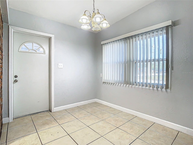 tiled foyer featuring a notable chandelier