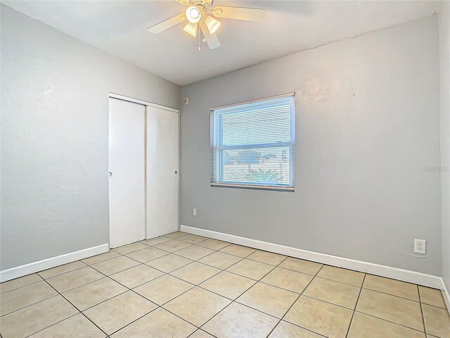 unfurnished bedroom featuring ceiling fan and a closet