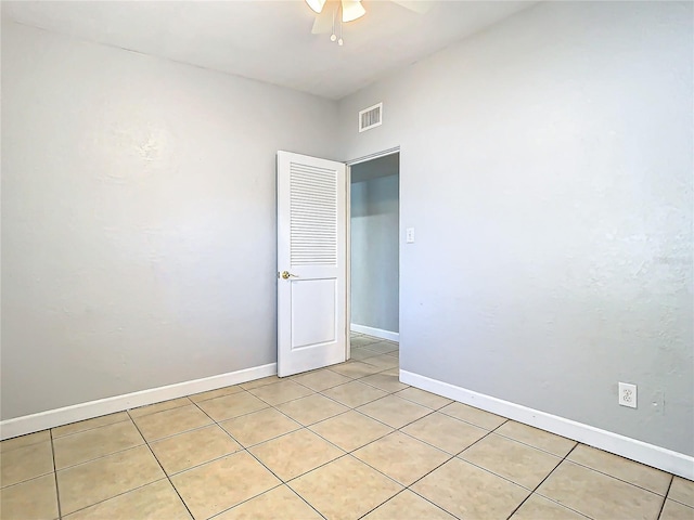 tiled empty room featuring ceiling fan