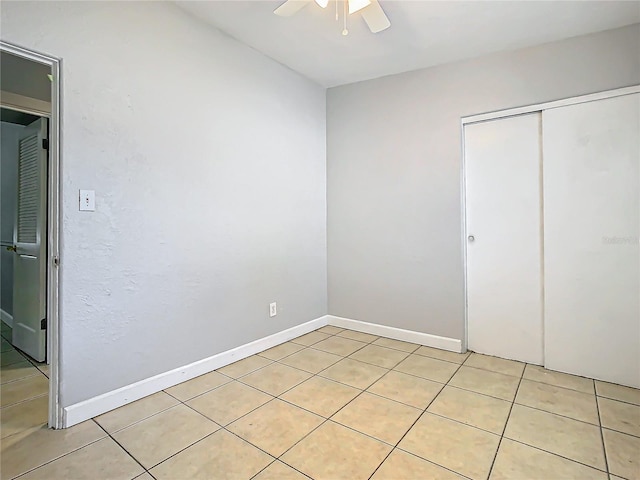 unfurnished bedroom featuring light tile patterned floors, a closet, and ceiling fan