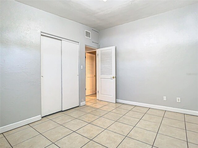 unfurnished bedroom with light tile patterned floors and a closet